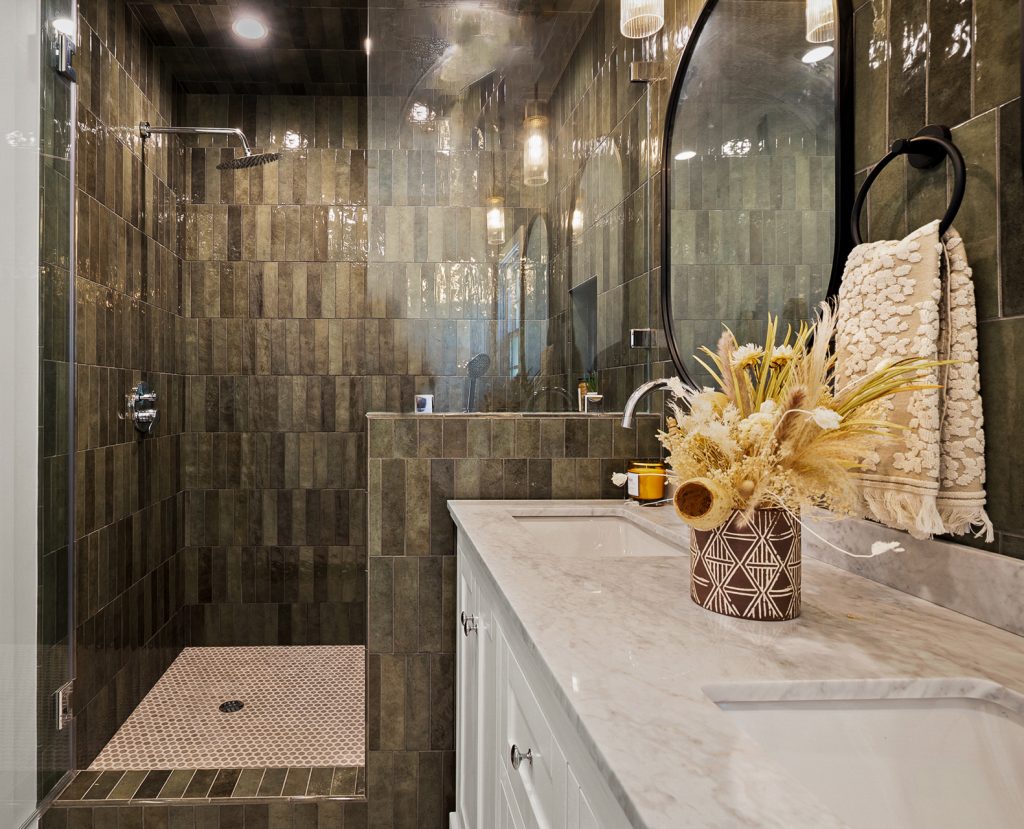 Guest bathroom shower detail with textured tile and brass fixtures