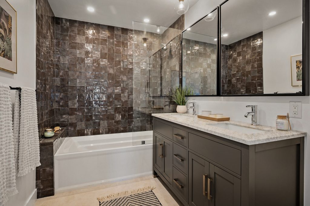 Guest bathroom lined in glazed brown zellige tile with a charcoal double vanity and marble top