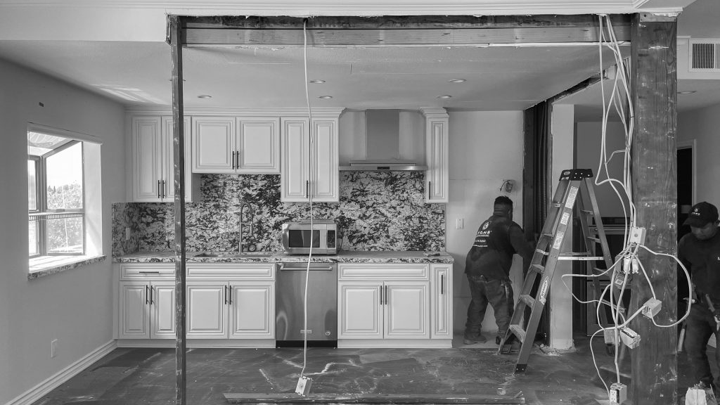 Kitchen during construction with the original cabinetry still in place and the wall opened on temporary shoring