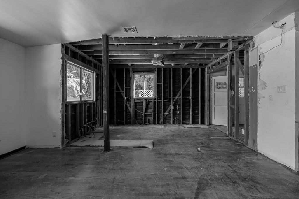 Kitchen during construction, stripped back to studs and subfloor with the ceiling opened up